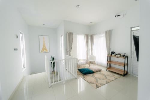 a living room with white walls and a white staircase at Akhtar Guest House Near Situ Gede in Tasikmalaya