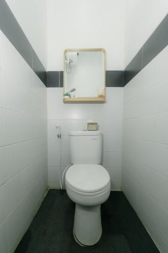 a bathroom with a white toilet and a mirror at Akhtar Guest House Near Situ Gede in Tasikmalaya