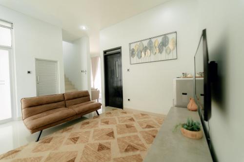a living room with a couch and a television at Akhtar Guest House Near Situ Gede in Tasikmalaya