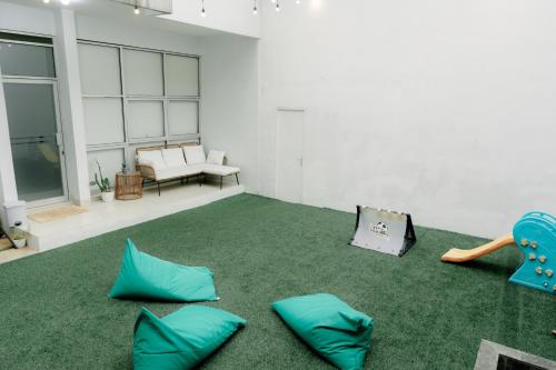 a living room with blue pillows on a green carpet at Akhtar Guest House Near Situ Gede in Tasikmalaya