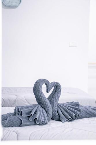 a grey blanket with a heart on a bed at Relax home in Ao Nang 
