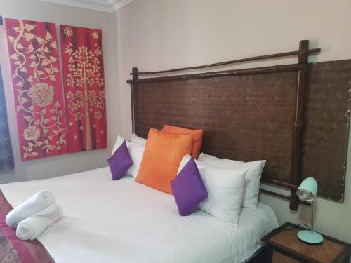 a bedroom with a white bed with colorful pillows at Midrand Conference Centre in Midrand
