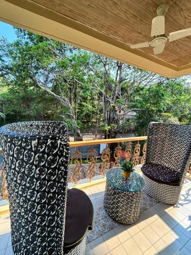 two chairs and a table on a balcony with trees at 360 Bliss Dia Hotels in Nerul