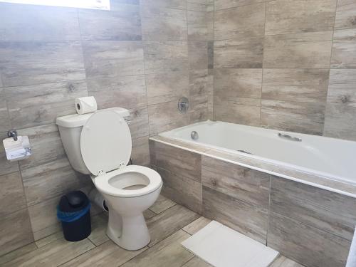 a bathroom with a toilet and a bath tub at Midrand Conference Centre in Midrand