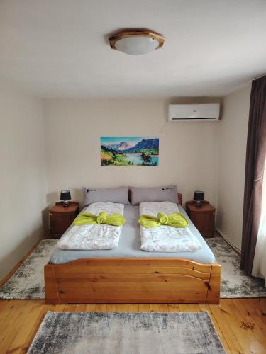 a bedroom with a bed with two yellow pillows at Къща за гости ФЪН ШУЙ 88 in Dobrinishte