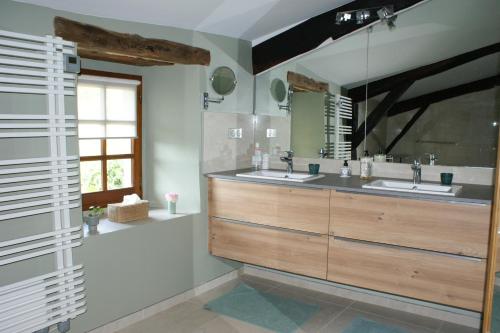 a bathroom with two sinks and a large mirror at L'Oustau de Pequeti in Laboule