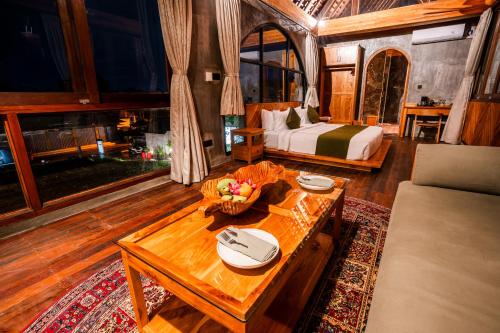 a bedroom with a bed and a table in a room at Villa Rabita in Ubud