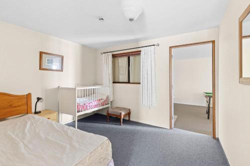 a bedroom with a bed and a crib and a mirror at Tokoeka in Parapara 