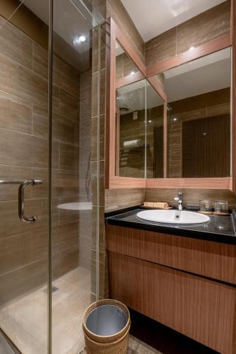 a bathroom with a sink and a glass shower at The Rivavi Legian in Legian