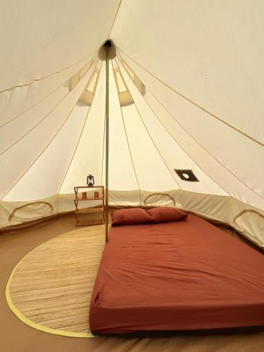 a tent with a red bed in a room at Bunihayu Forest in Peuteuy