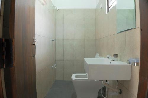a bathroom with a toilet and a sink at Wilpattu Restaurant & Guest house in Pahala Maragahawewa