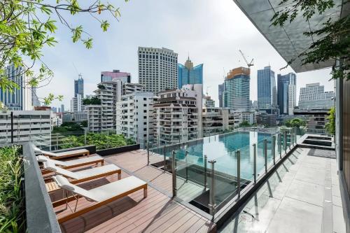 a balcony with a swimming pool and a city skyline at Circle S Sukhumvit 12 Bangkok in Bangkok