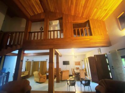 una sala de estar con una gran casa de madera en Arverne Villa Kandy, en Kandy