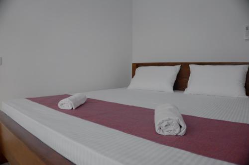 a bed with two towels sitting on top of it at Wilpattu Restaurant & Guest house in Pahala Maragahawewa