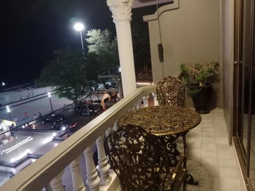 a table and chairs on a balcony at night at HiSSS Style ชะอำ in Cha Am