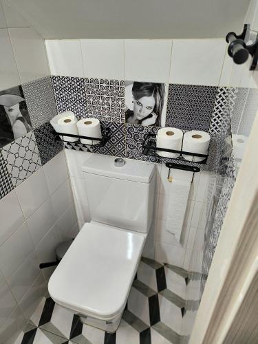 a bathroom with a toilet with a picture on the wall at WHITE House in Burgos