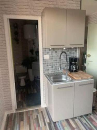 une petite cuisine avec un évier et un comptoir dans l'établissement Studio bord de mer plage Barcares Pyrénées O, au Barcarès