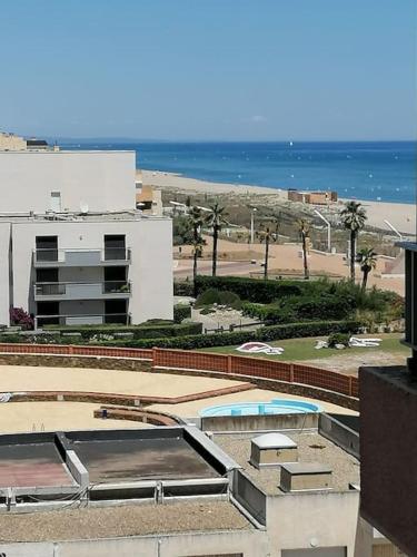 - une vue sur un bâtiment avec une piscine et la plage dans l'établissement Studio bord de mer plage Barcares Pyrénées O, au Barcarès