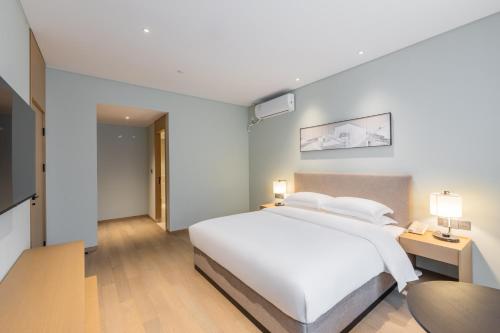 Ein Bett oder Betten in einem Zimmer der Unterkunft 濮院时尚古镇濮锦大酒店