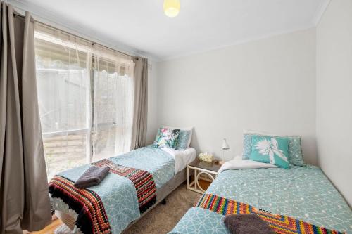 due letti in una stanza con finestra di 2 Russell a Anglesea