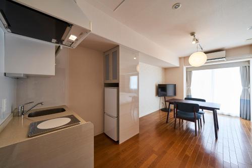 a kitchen and dining room with a table and a refrigerator at Hotel Global View Hakodate in Hakodate