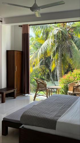 a bedroom with a bed and a large window at Shades Hotel & Villa in Matara
