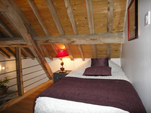ゴンヌヴィル・シュル・オンフロールにあるLa Petite Chaumièreの木製の天井の客室で、ベッドルーム1室(ベッド1台付)