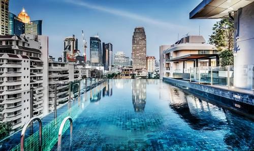 a swimming pool with a city skyline in the background at Circle REIN Sukhumvit 12 Bangkok in Bangkok
