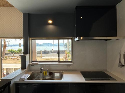 a kitchen with a sink and a window at Orange open-air bath of East Villa-winter only- in Onomichi