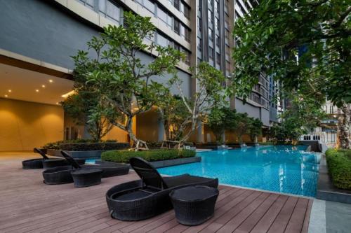 une cour d'hôtel avec une piscine, des chaises et des arbres dans l'établissement 8 Kia Peng Suites KLCC by Luna, à Kuala Lumpur