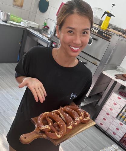 a woman in a kitchen holding a tray of pretzels at LAM BUNGALOW Resort & Spa in Phu Quoc