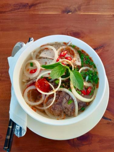 a bowl of soup on a wooden table at LAM BUNGALOW Resort & Spa in Phu Quoc