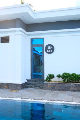 a house with a blue door next to a swimming pool at LAM BUNGALOW Resort & Spa in Phu Quoc