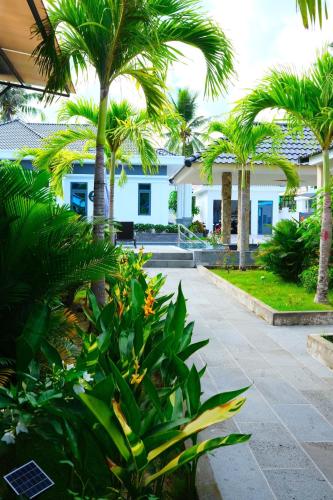 a courtyard with palm trees and a building at LAM BUNGALOW Resort & Spa in Phu Quoc