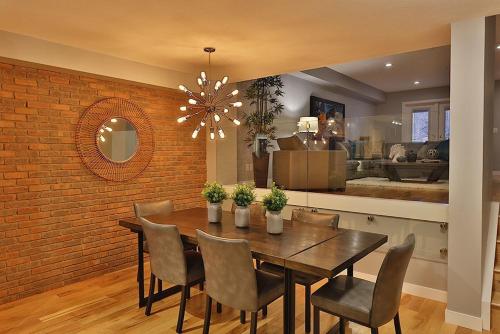 a dining room with a brick wall and a table and chairs at Ice District 2 Kings Underground Park Patio in Edmonton