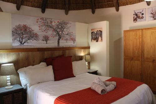 a bedroom with a bed with a towel on it at Honey Lodge in Klipdrift