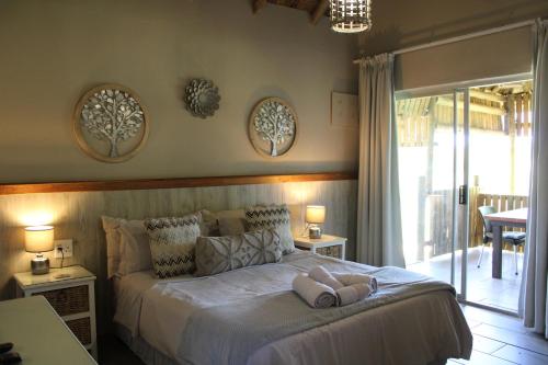 a bedroom with a bed with two dolls on it at Honey Lodge in Klipdrift