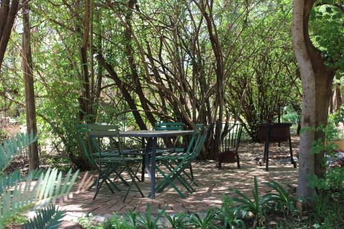 a table and chairs sitting under a tree at Honey Lodge in Klipdrift