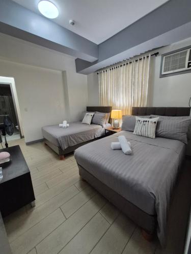 Habitación grande con 2 camas y sofá en 101newport Condotel Near NAIA T3, en Manila