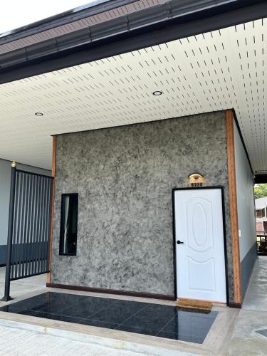a white door on the side of a building at Phangnga Save House - เซฟเฮาส์พังงา in Phangnga