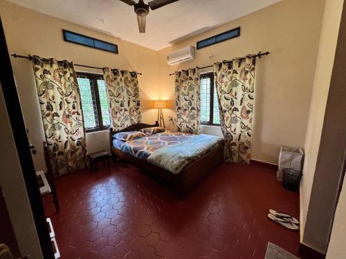 a bedroom with a bed and some windows at Prabhalayam in Kottayam