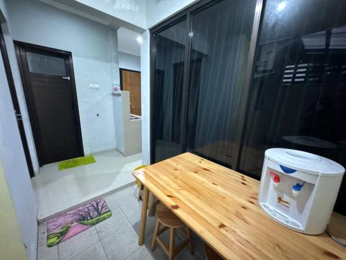a room with a wooden table and a glass wall at Omah Putih Homestay Jogja in Jarakan
