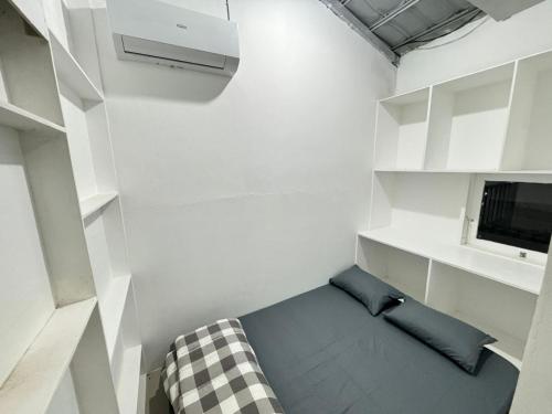 a small room with a couch and a tv at Omah Putih Homestay Jogja in Jarakan