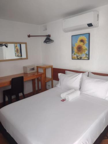 a bedroom with a bed and a desk with a computer at Casa Marqués del Pedregal in Cartagena de Indias