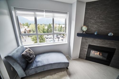 a living room with a chair and a fireplace at Upscale Modern Apartment in Whistler