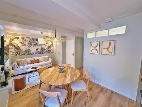 a living room with a table and chairs and a couch at La Maison Cavet 5 Appartements de standing au cœur du village in Sanary-sur-Mer