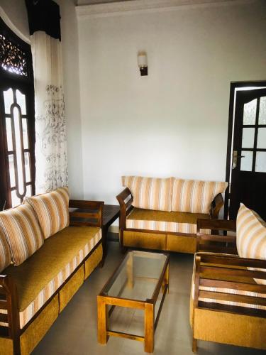 a living room with couches and a coffee table at The Moon Lodge in Aluthgama