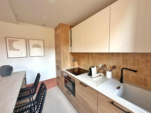 a kitchen with a sink and a counter top at La Maison Cavet 5 Appartements de standing au cœur du village in Sanary-sur-Mer