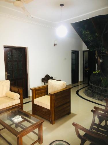 a living room with two chairs and a coffee table at The Moon Lodge in Aluthgama