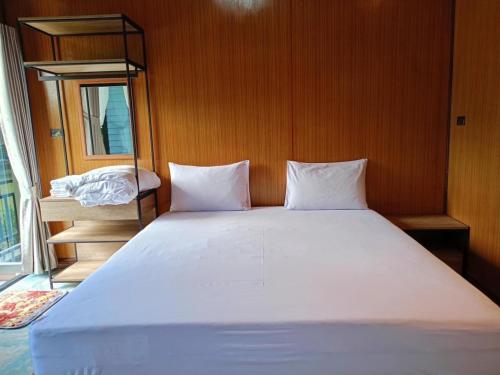 a large white bed in a room with a window at Phangnga Save House - เซฟเฮาส์พังงา in Phangnga
